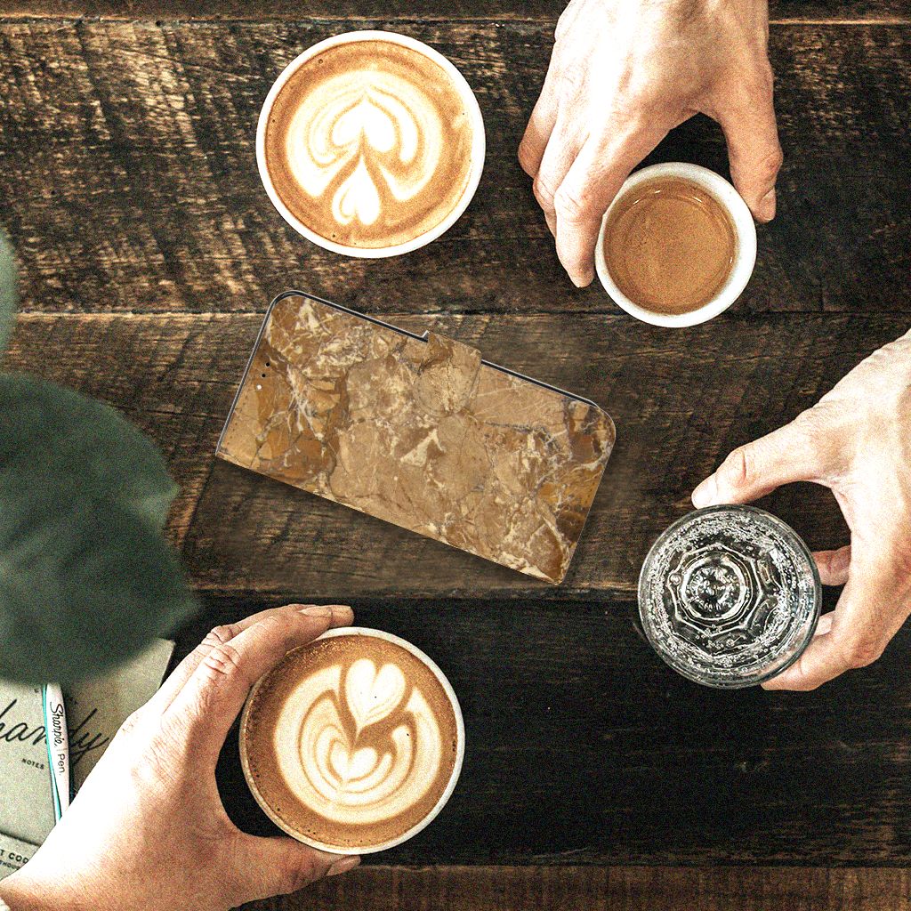 Xiaomi Redmi 9T | Poco M3 Bookcase Marmer Creme op een houten tafel met koffiekopjes.