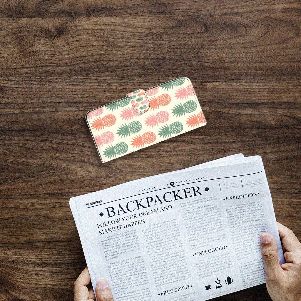 Samsung Galaxy A14 4G Book Cover Ananas on a wooden table next to a newspaper.