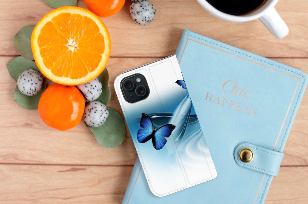 iPhone 15 Hoesje maken Vlinders met blauwe vlinders en een stijlvolle agenda op een houten tafel