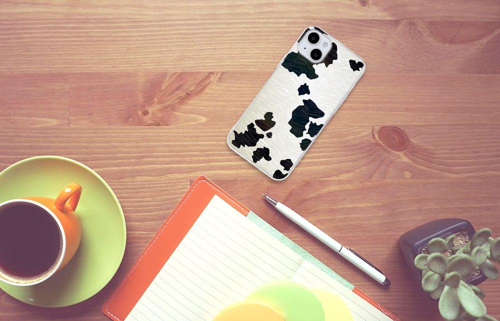 iPhone 15 Plus TPU Hoesje Koeienvlekken op een bureau met een kopje koffie en een notitieboekje.