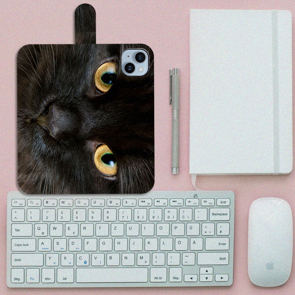 iPhone 15 Plus Telefoonhoesje met Pasjes Zwarte Kat met schattig zwart kattenontwerp en op de achtergrond een toetsenbord.