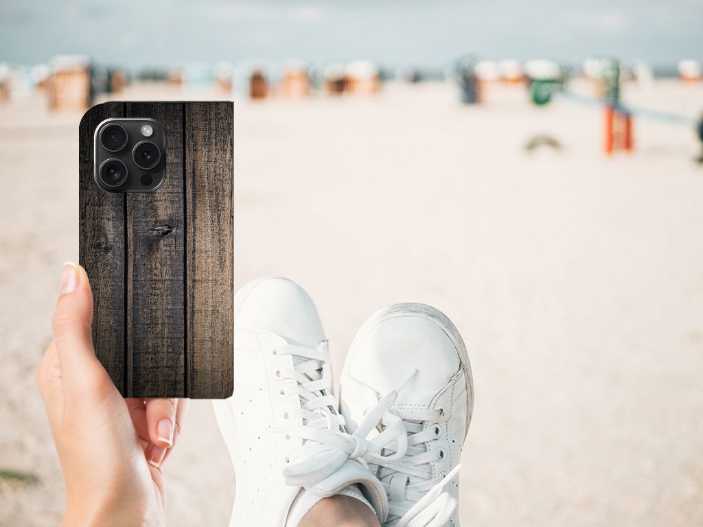 iPhone 15 Pro Book Wallet Case Steigerhout in hand met sneakers op het strand đī¸