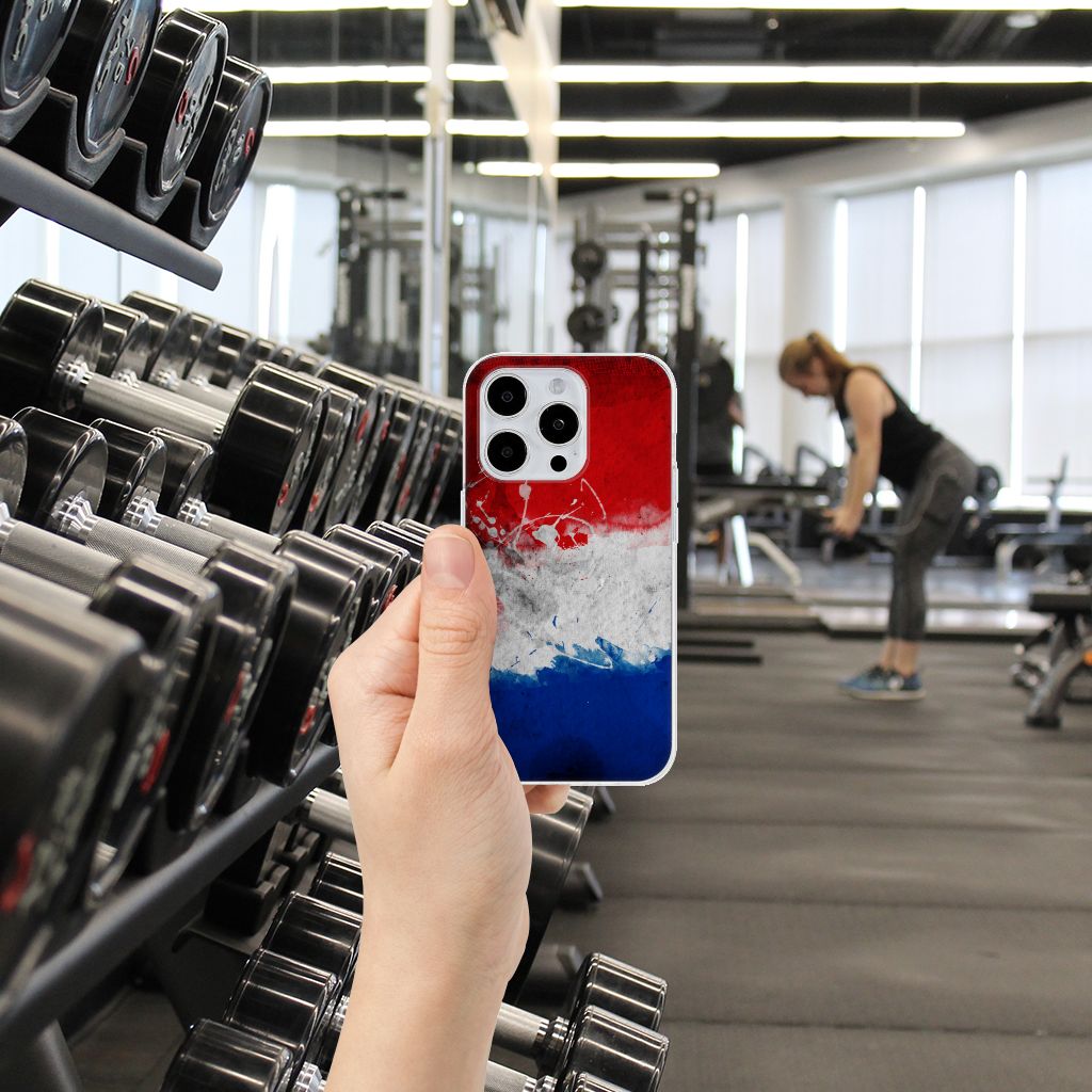 iPhone 15 Pro Hoesje Nederland met Nederlandse vlag in sportschool, sportieve vrouw op achtergrond.