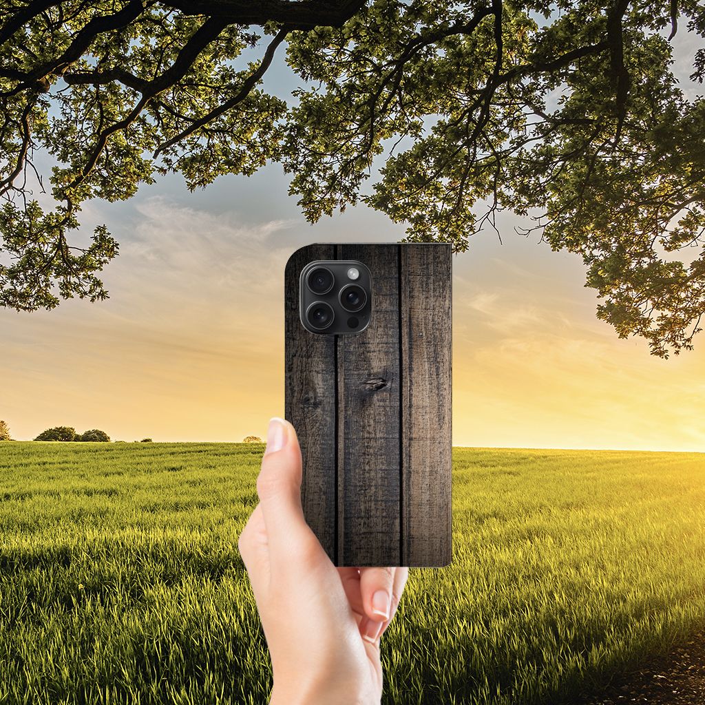 iPhone 15 Pro Max Book Wallet Case Steigerhout met een rustieke uitstraling, vastgehouden tegen een achtergrond van natuur đŗ.