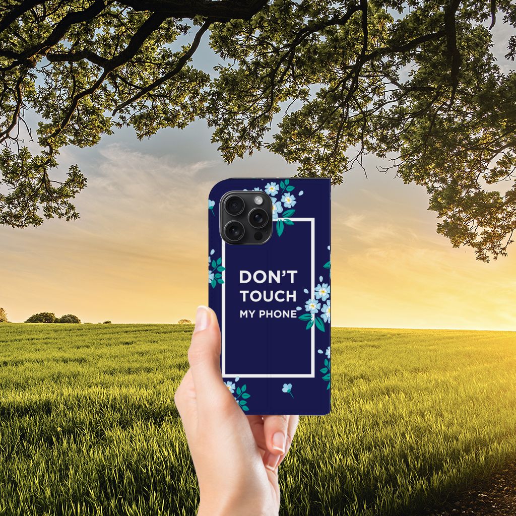 iPhone 15 Pro Max Design Case Flowers Blue DTMP met bloemen design en tekst in hand onder een boom.