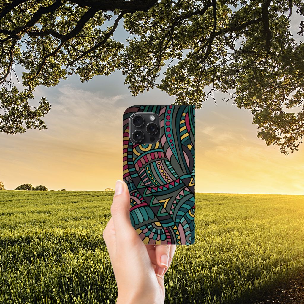 iPhone 15 Pro Max Hoesje met Magneet Aztec in kleurrijk retro ontwerp, vastgehouden in hand bij een zonsondergang đ
.