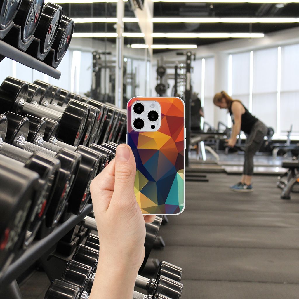 iPhone 15 Pro TPU Hoesje Polygon Color in een sportschool met gewichten op de achtergrond.