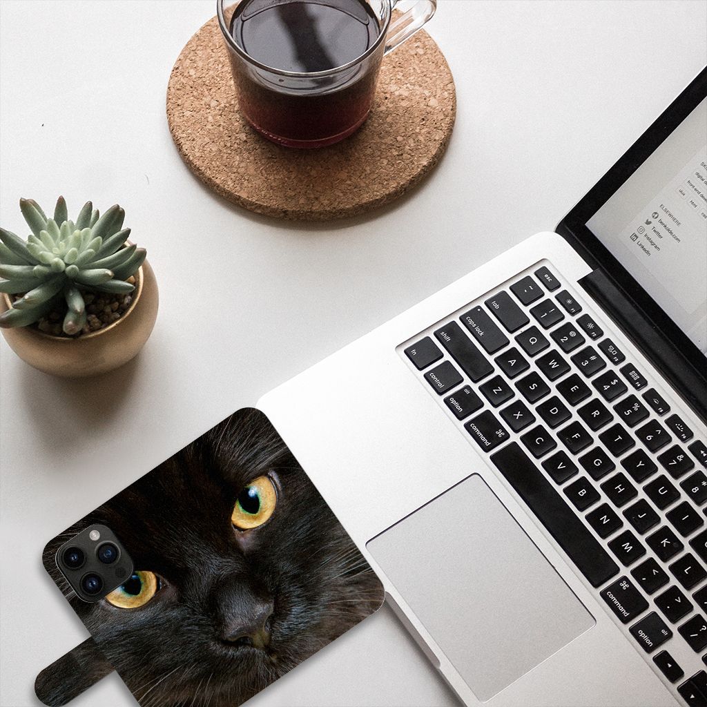 iPhone 15 Pro Telefoonhoesje met Pasjes Zwarte Kat op bureau naast laptop en koffie, mysterieus ontwerp.