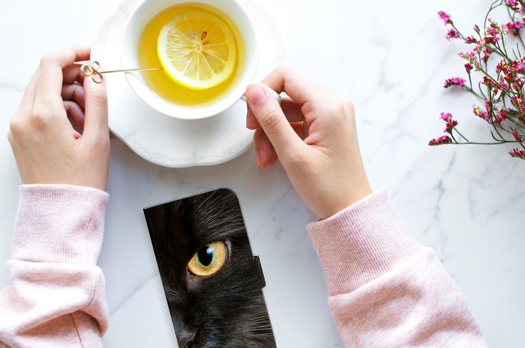iPhone 15 Telefoonhoesje met Pasjes Zwarte Kat met een prachtige close-up van een zwarte kat en een kopje thee.
