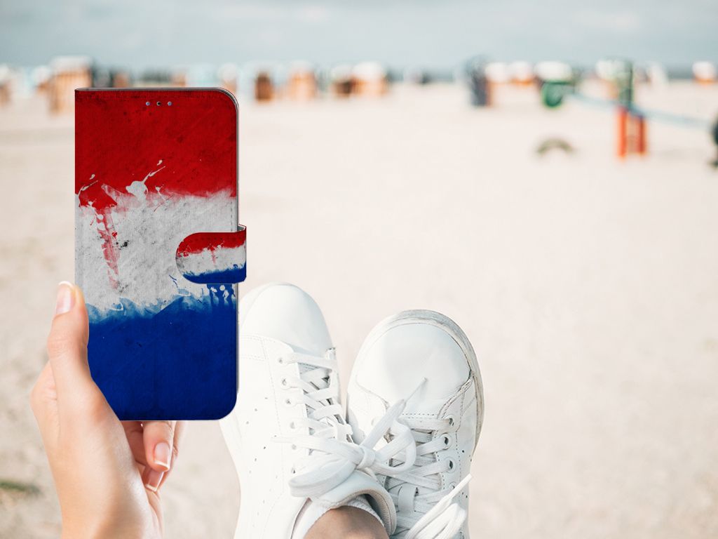 Hand holding Samsung Galaxy A03s Bookstyle Case Nederland with Dutch flag design at the beach