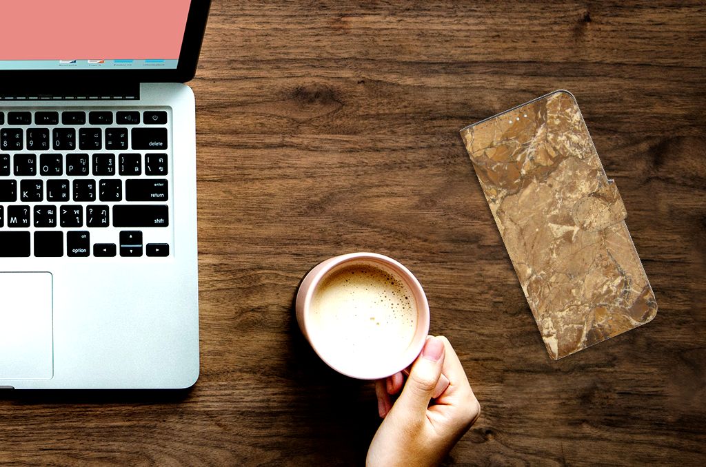 Xiaomi Mi 10T Lite Bookcase Marmer Creme naast een laptop en een kop koffie op een houten tafel.