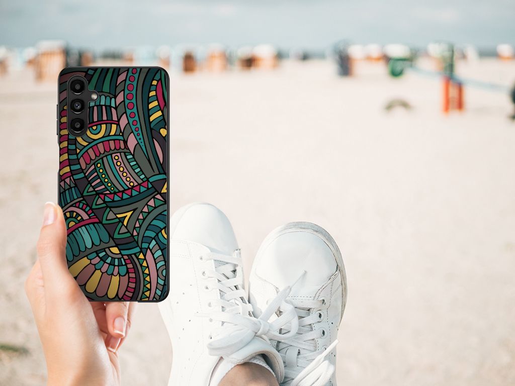 Samsung Galaxy A14 5G Back Case Aztec design held by a person in sneakers at the beach.
