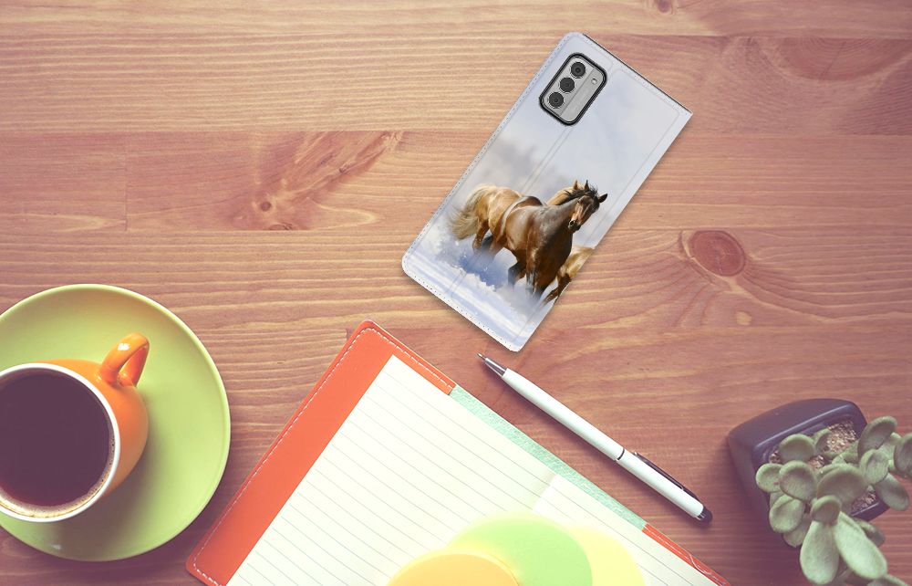 Nokia G42 Hoesje maken Paarden met afbeelding van galloperende paarden op een houten tafel met accessoires.