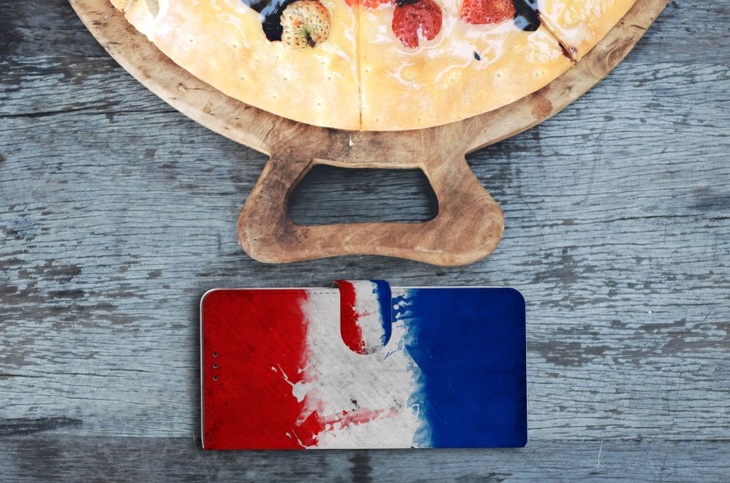 OnePlus 9 Pro Bookstyle Case Nederland met artistieke Nederlandse vlag op houten tafel naast pizza.