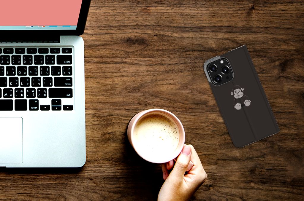iPhone 13 Pro Magnet Case Gorilla met schattige aapjesprint en pasjesvak, naast een laptop en een kopje koffie ☕.