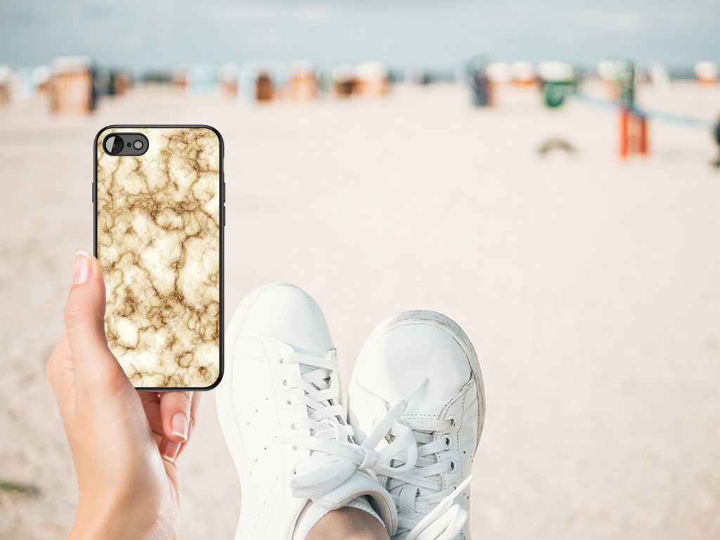iPhone SE 2022 | SE 2020 | 7/8 Marmeren Print Telefoonhoesje Marmer Goud in hand op het strand.