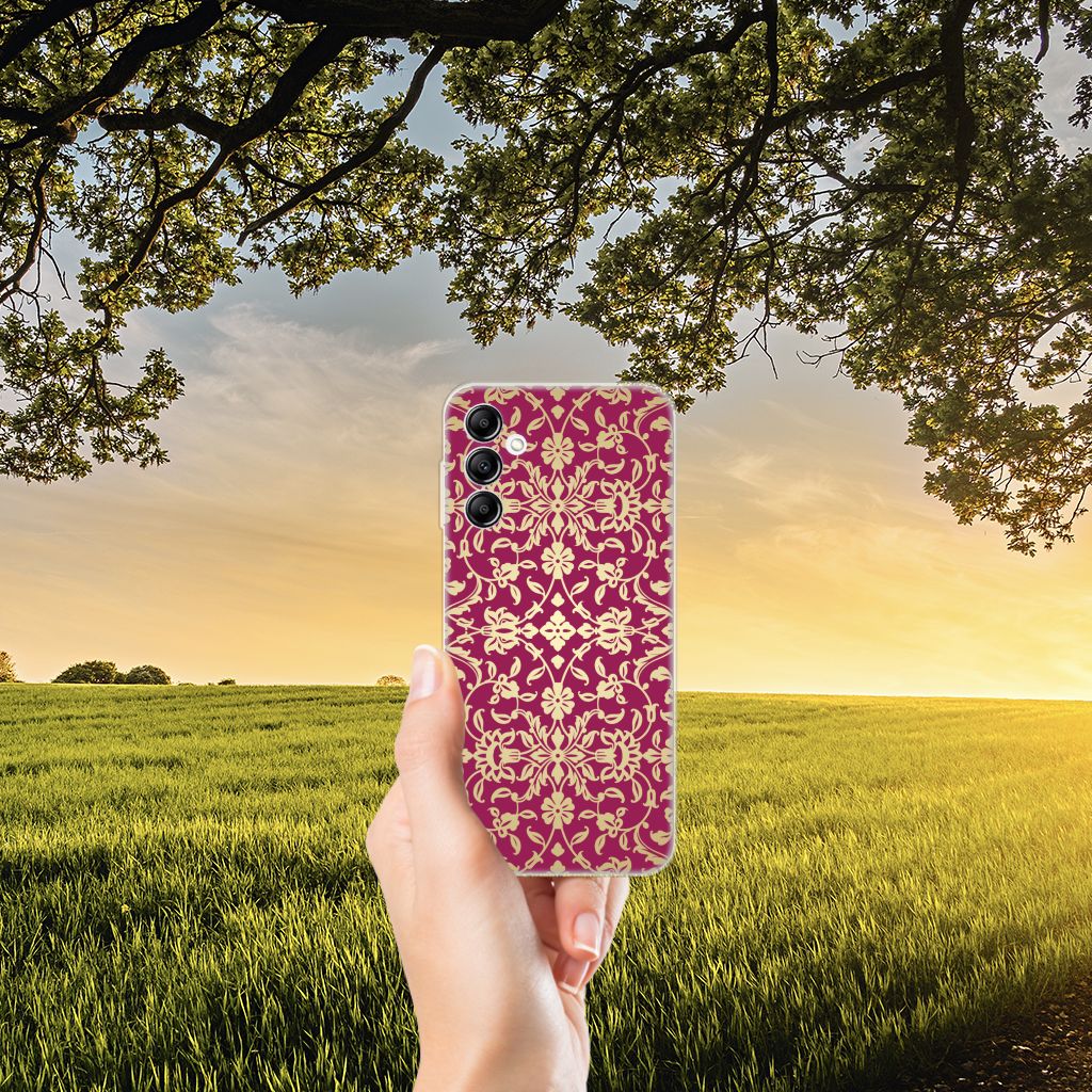 Siliconen Hoesje Samsung Galaxy A14 5G Barok Pink gehouden tegen een zonsetting achtergrond in een veld.