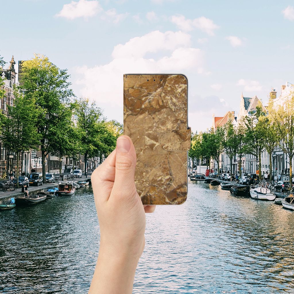 Alcatel 1S 2020 Bookcase Marmer Creme in hand by a canal in Amsterdam, showcasing its luxurious marble-like design.