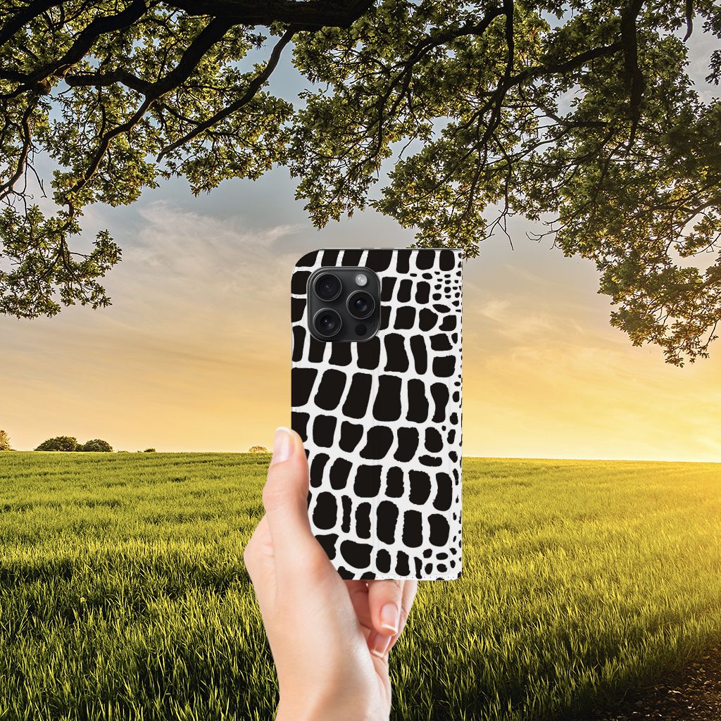 iPhone 15 Pro Max Hoesje maken Slangenprint met zwarte en witte slangenprint, gehouden tegen een zonsondergang.