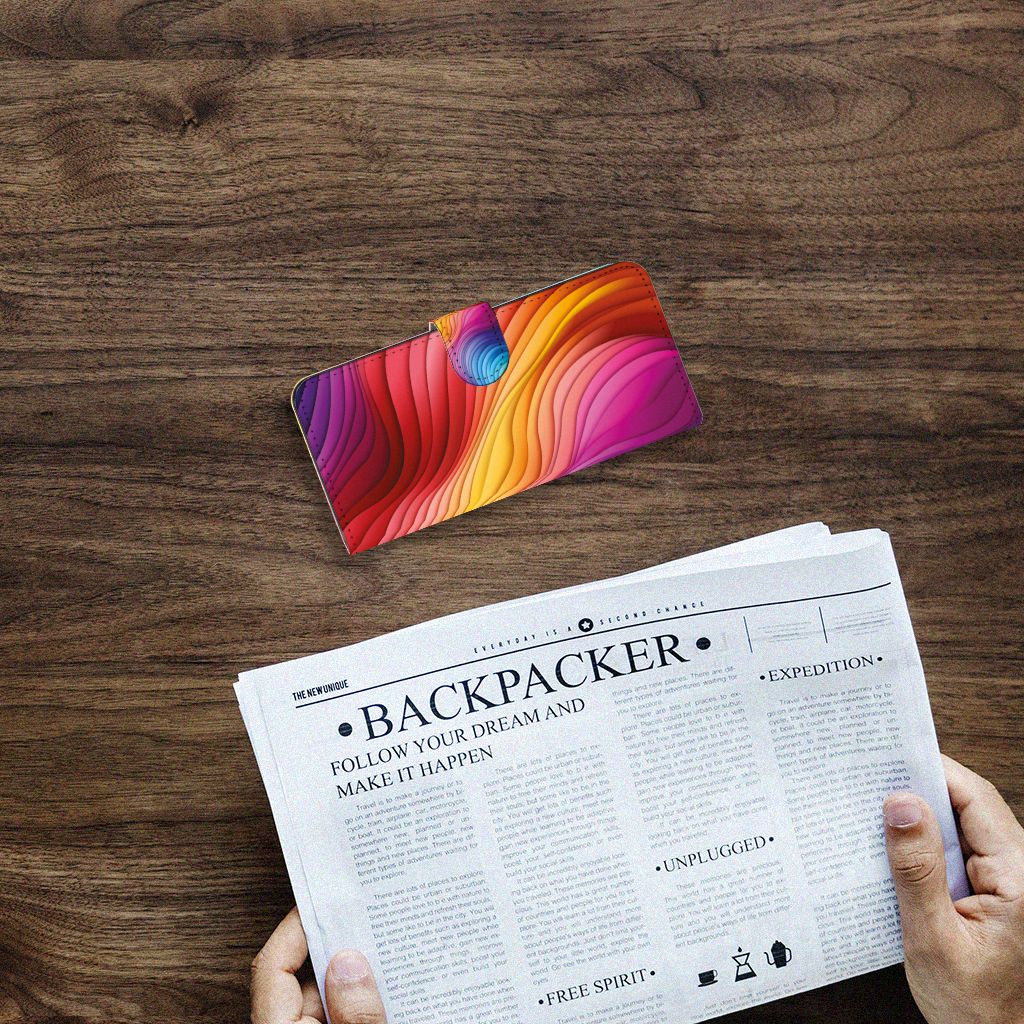 Book Case voor Samsung Galaxy A14 4G Regenboog op een houten tafel met een krant.