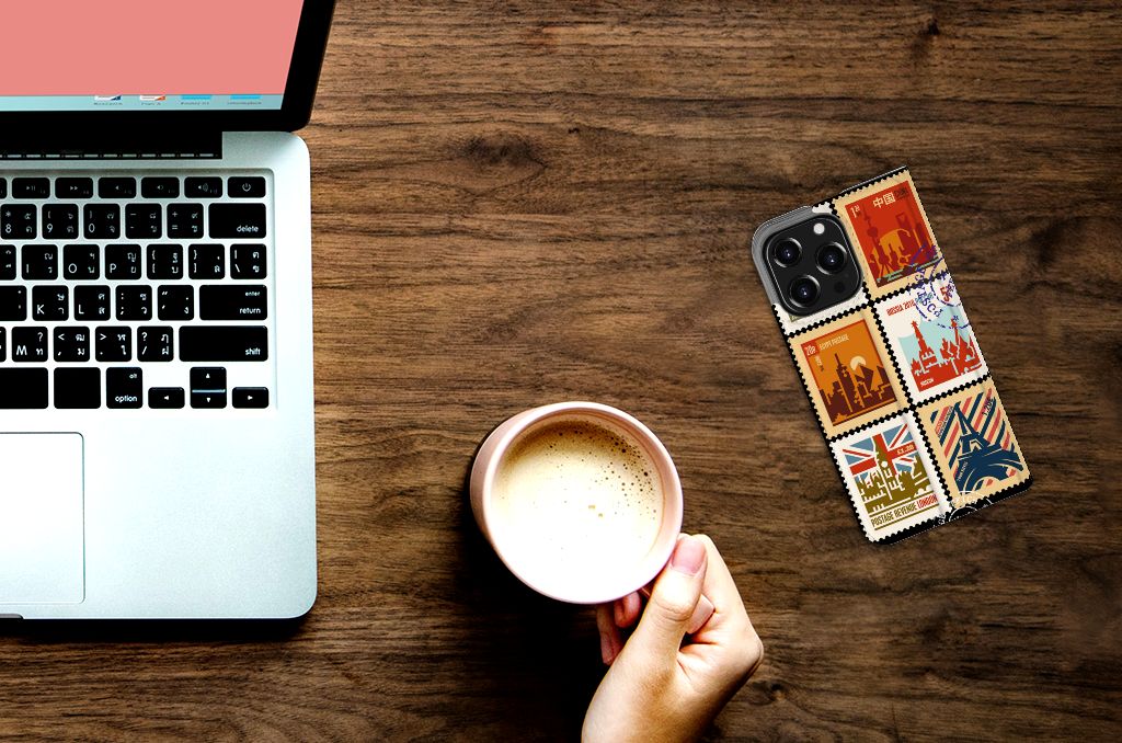 iPhone 13 Pro Book Cover Postzegels met verschillende postzegels, liggend naast een laptop en een mok koffie.