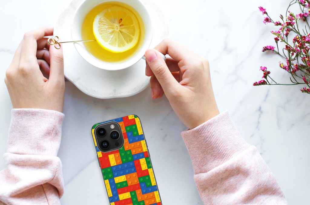 iPhone 15 Pro Back Case Blokken met kleurrijk patroon, hand met thee en limoen op tafel.