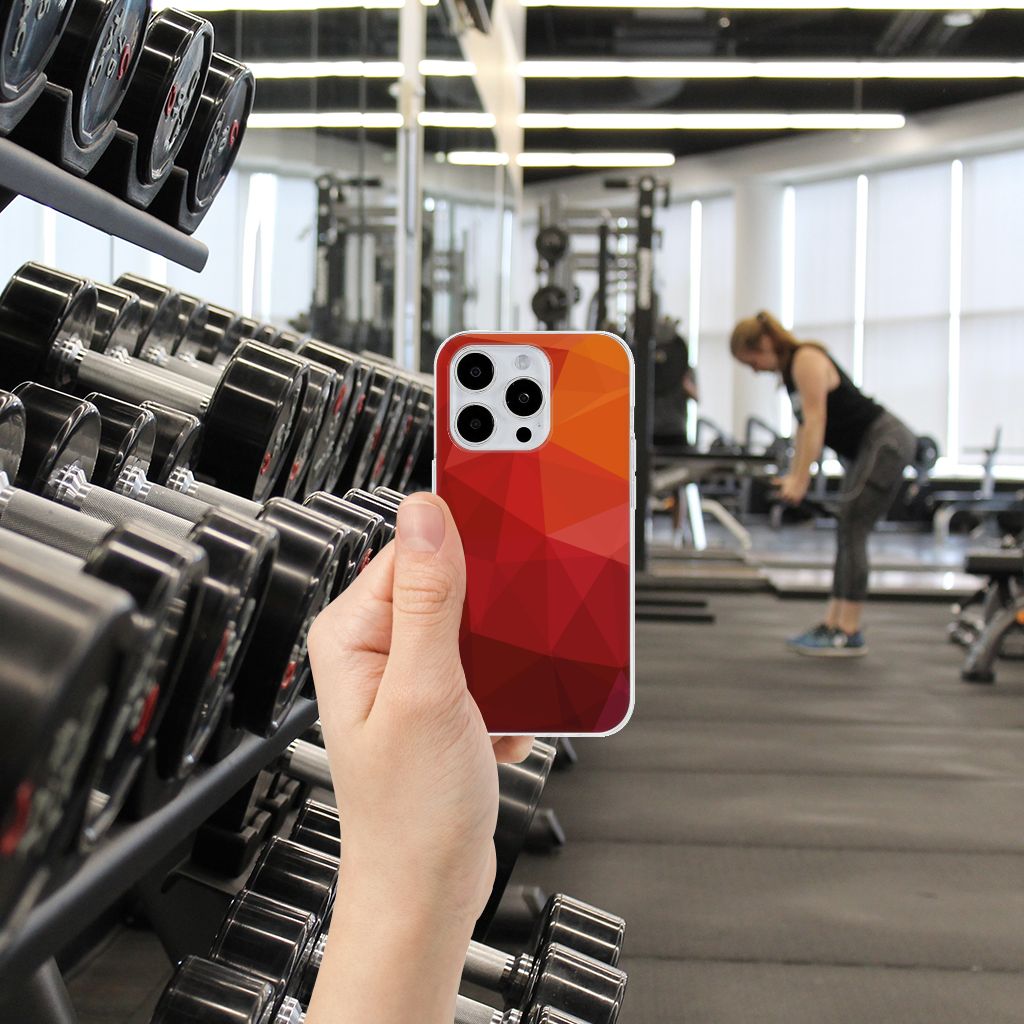 TPU Hoesje voor iPhone 15 Pro Polygon Red in een fitnessomgeving met gewichten op de achtergrond.