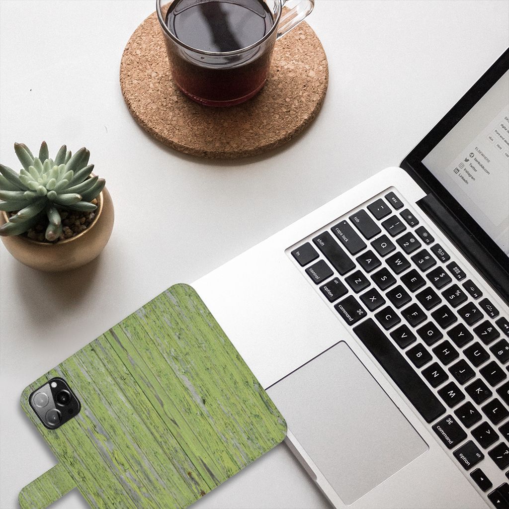 iPhone 13 Pro Max Book Style Case Green Wood op een bureau met een laptop en een plant.