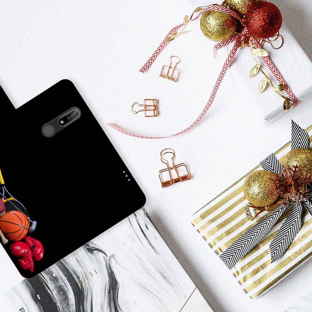 Nokia 2.4 Wallet Case met Pasjes Sports met basketbal en bokshandschoenen op een tafel met kerstdecoratie.