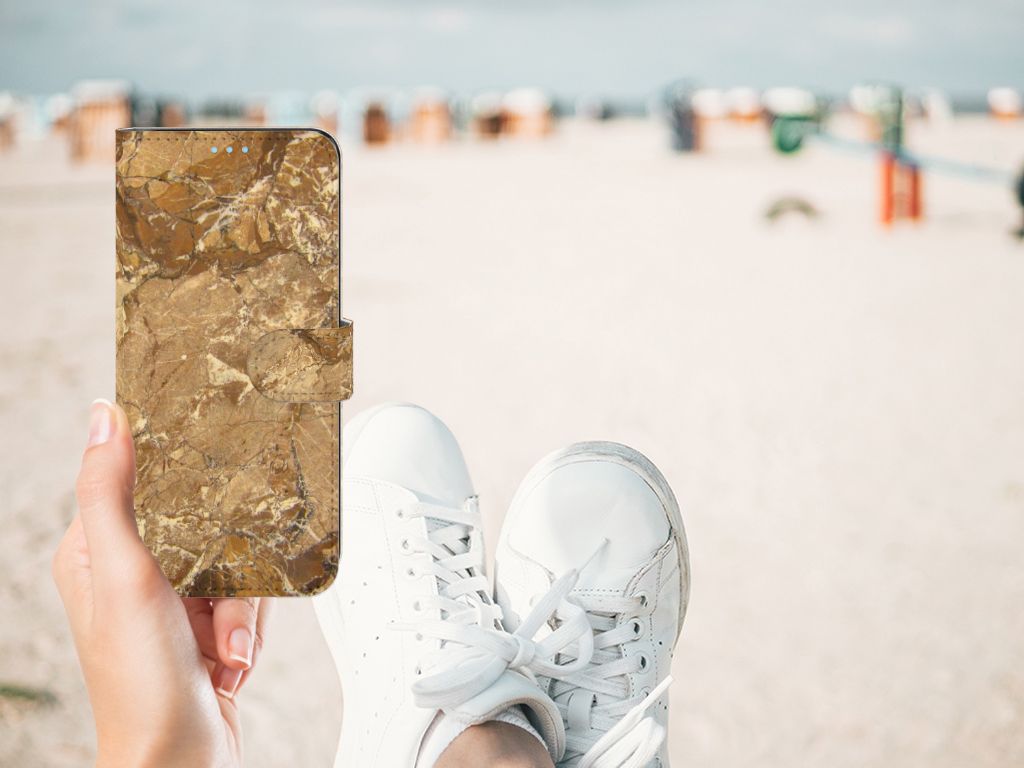 OPPO A74 4G Bookcase Marmer Creme in hand on beach with white sneakers.