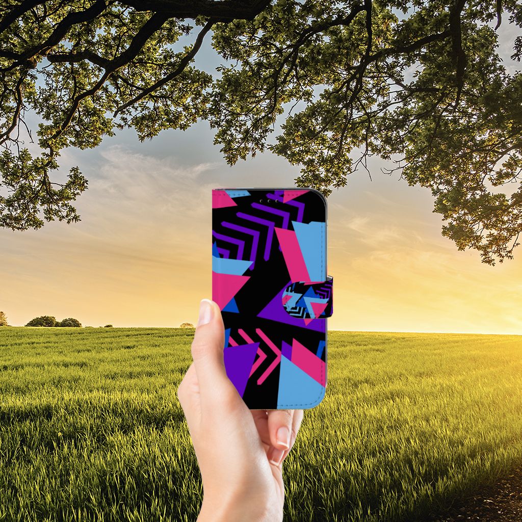 Apple iPhone 13 Book Case Funky Triangle in hand with colorful geometric design against a sunset backdrop.