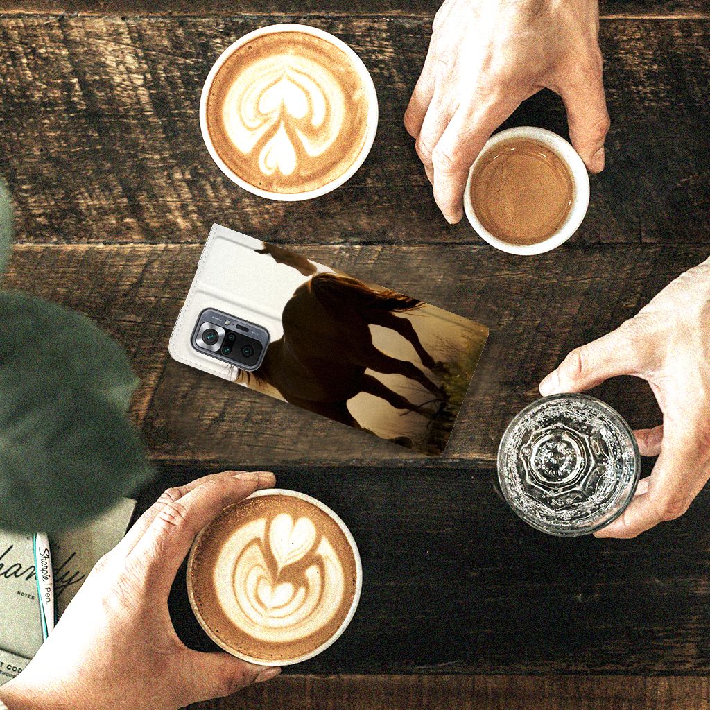 Xiaomi Redmi Note 10 Pro Hoesje maken Design Cowboy met paardenprint op een houten tafel met koffie.