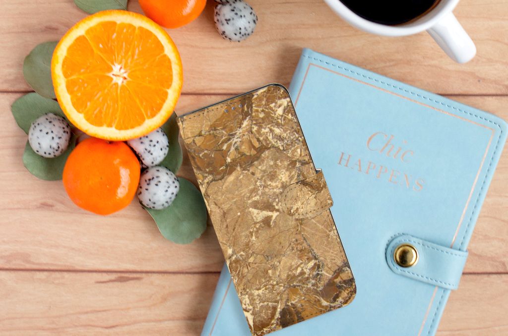 OnePlus 10 Pro Bookcase Marmer Creme met luxe uitstraling naast fruit en planner op houten tafel.