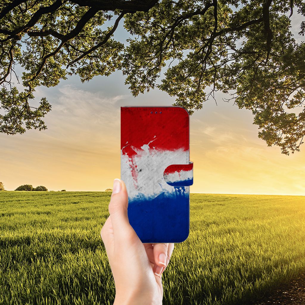 OnePlus Nord CE 2 Bookstyle Case Nederland met artistiek design van de Nederlandse vlag in hand bij zonsondergang.