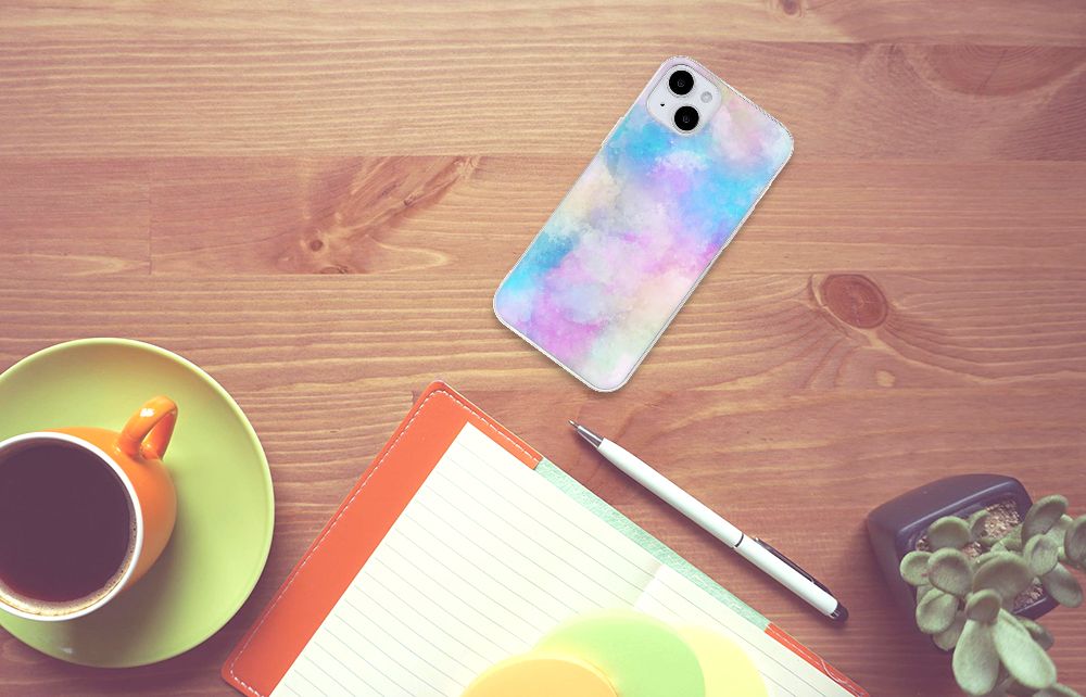 Hoesje maken iPhone 15 Plus Watercolor Light op een houten tafel met een kopje koffie en een notitieboek.