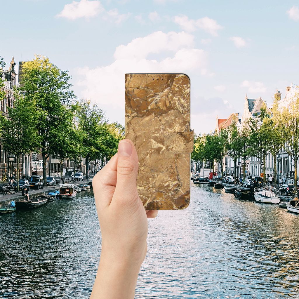 OnePlus Nord 2 5G Bookcase Marmer Creme in hand by a canal in a scenic city view.