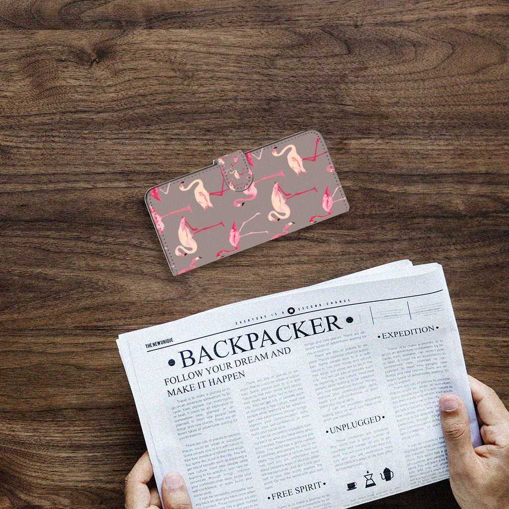Samsung Galaxy A14 4G Telefoonhoesje met Pasjes Flamingo op een houten tafel met een krant eronder.