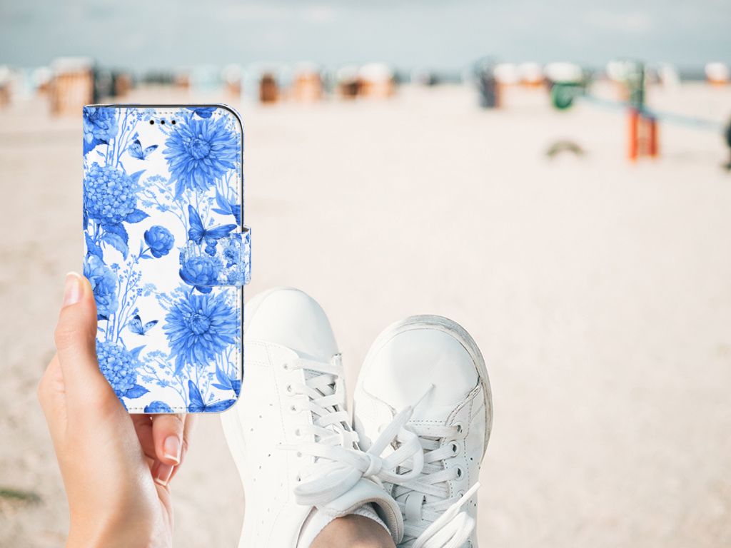 Hoesje voor Apple iPhone 11 Flowers Blue met blauw bloemendecor op een achtergrond van het strand, sneakers zichtbaar.