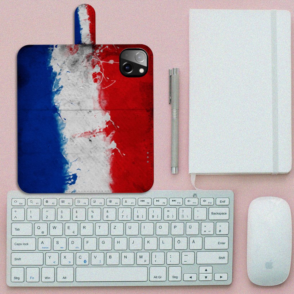 iPhone 14 Plus Bookstyle Case Nederland met artistiek design van de Nederlandse vlag op een bureau.