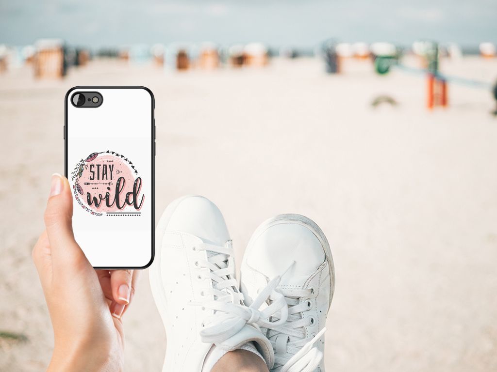 iPhone SE 2022 | SE 2020 | 7/8 Hoesje Boho Stay Wild in hand with ocean background and white sneakers.