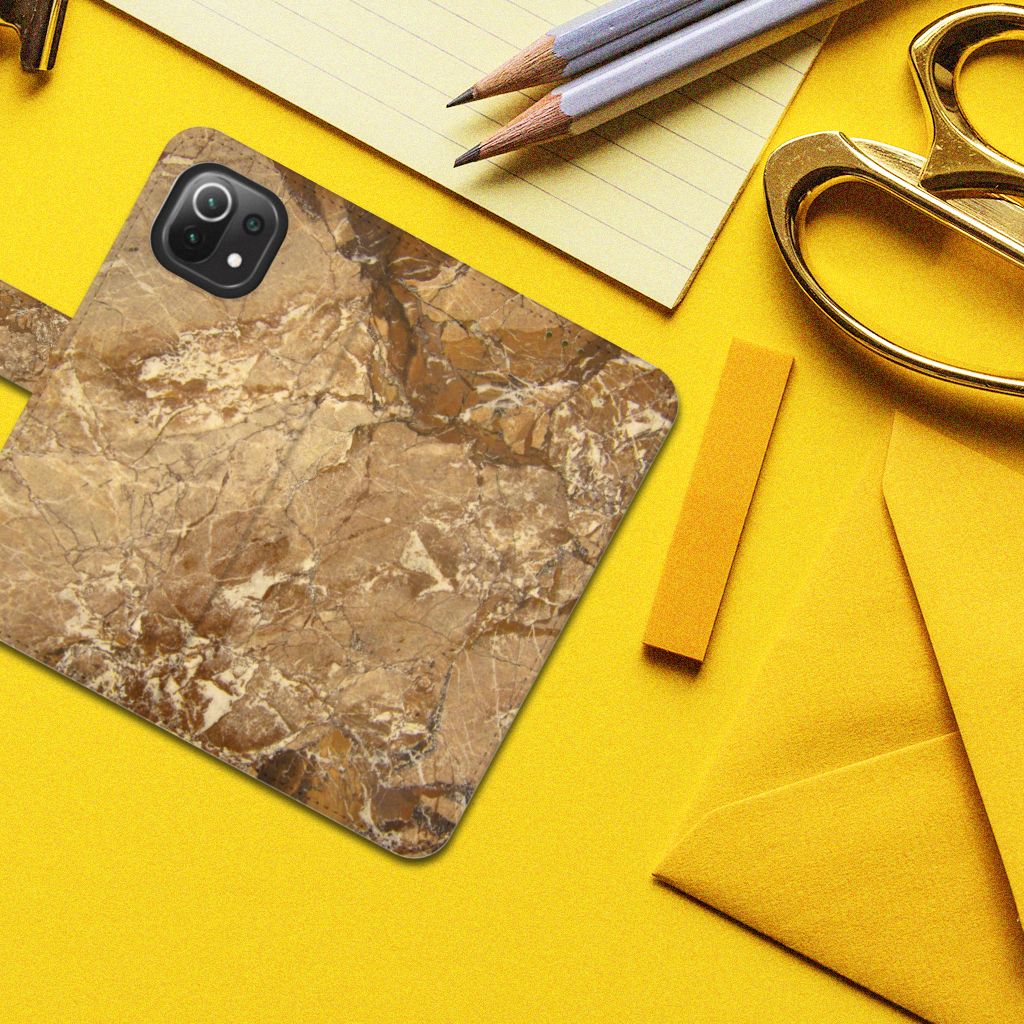 Xiaomi 11 Lite 5G NE | Mi 11 Lite Bookcase Marmer Creme op een gele achtergrond met kantoorbenodigdheden.