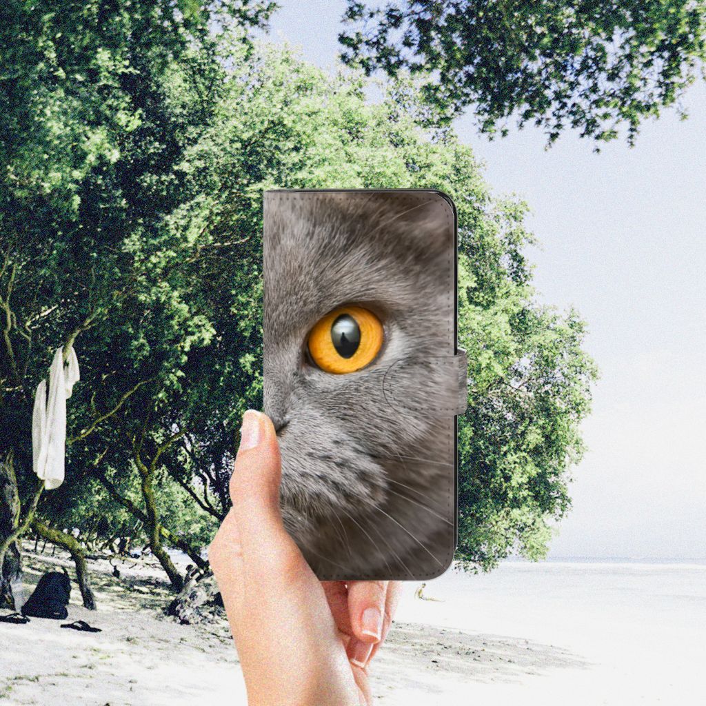 Telefoonhoesje met Pasjes Samsung Galaxy A34 Britse Korthaar met kattenoog in hand op strand achtergrond.