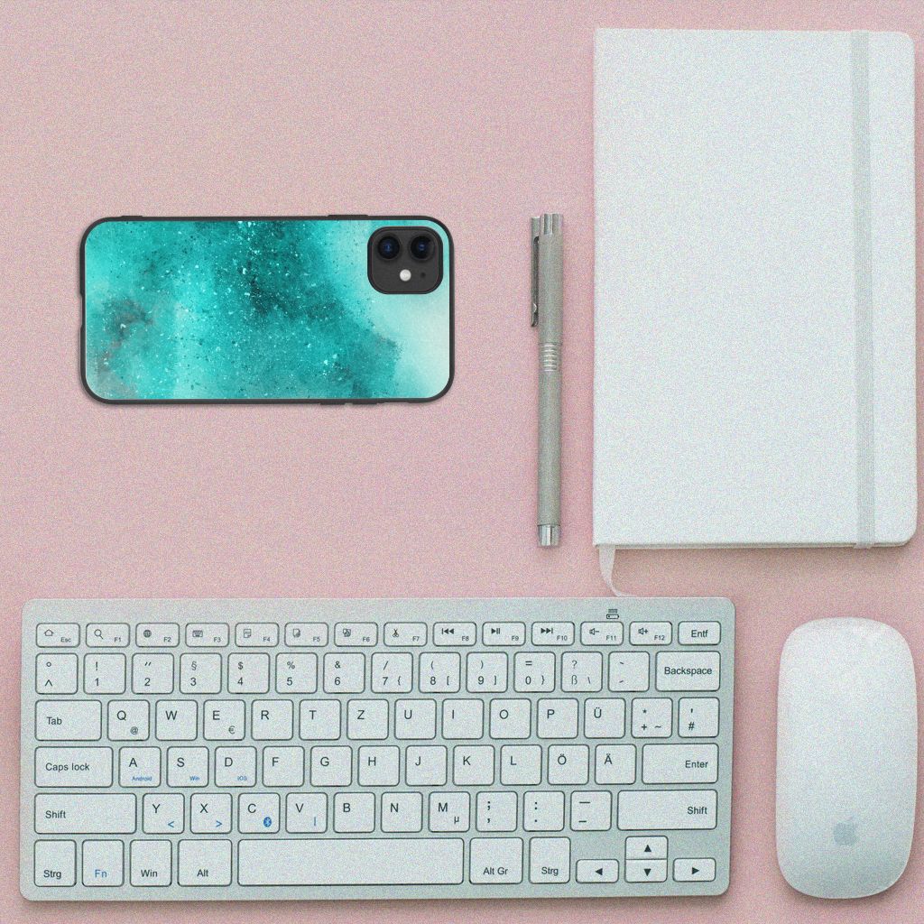 Kleurrijke Telefoonhoesje iPhone 11 Painting Blue op een bureau met toetsenbord en notitieboek.