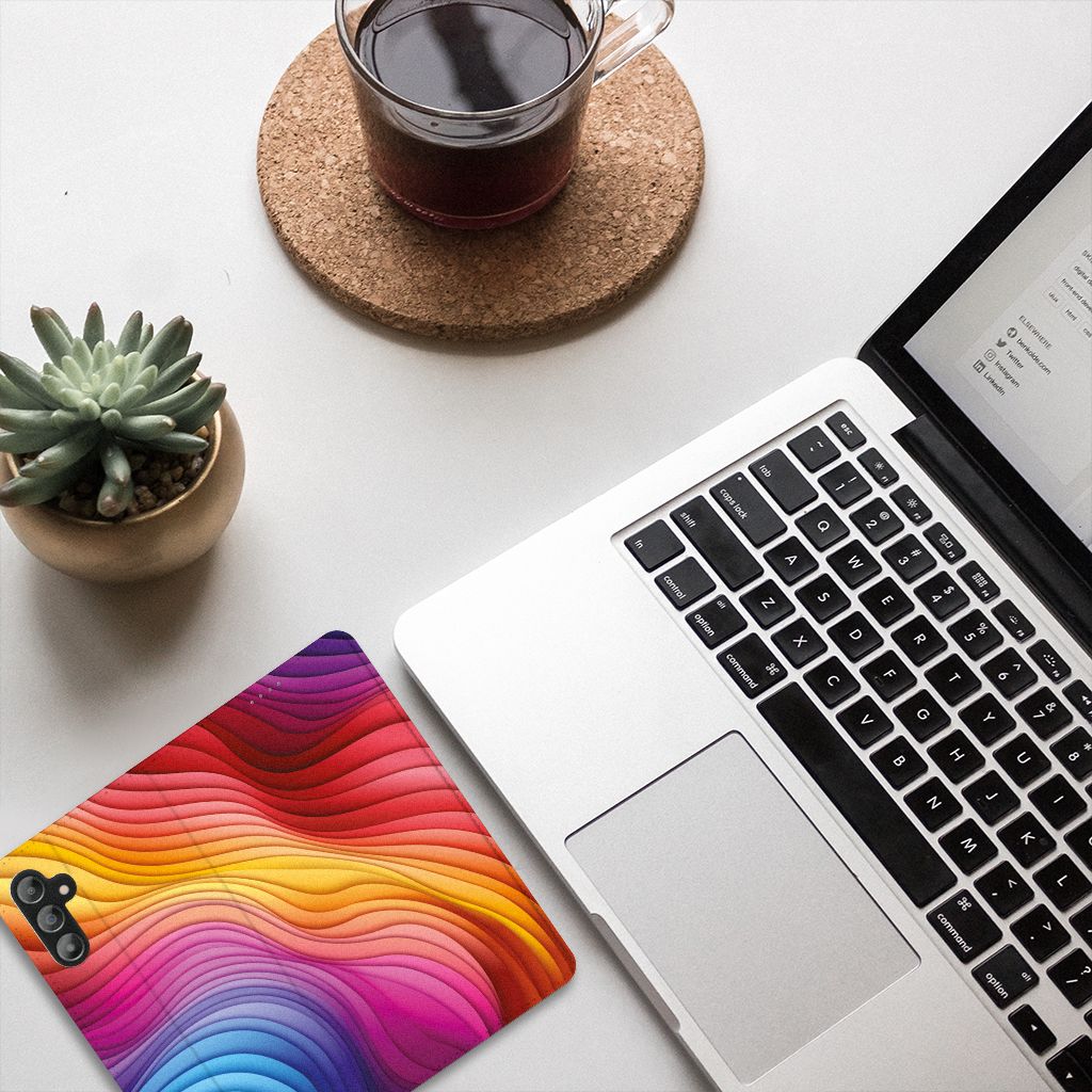 Stand Case voor Samsung Galaxy A14 5G Regenboog met kleurrijke golfpatronen op een bureau.