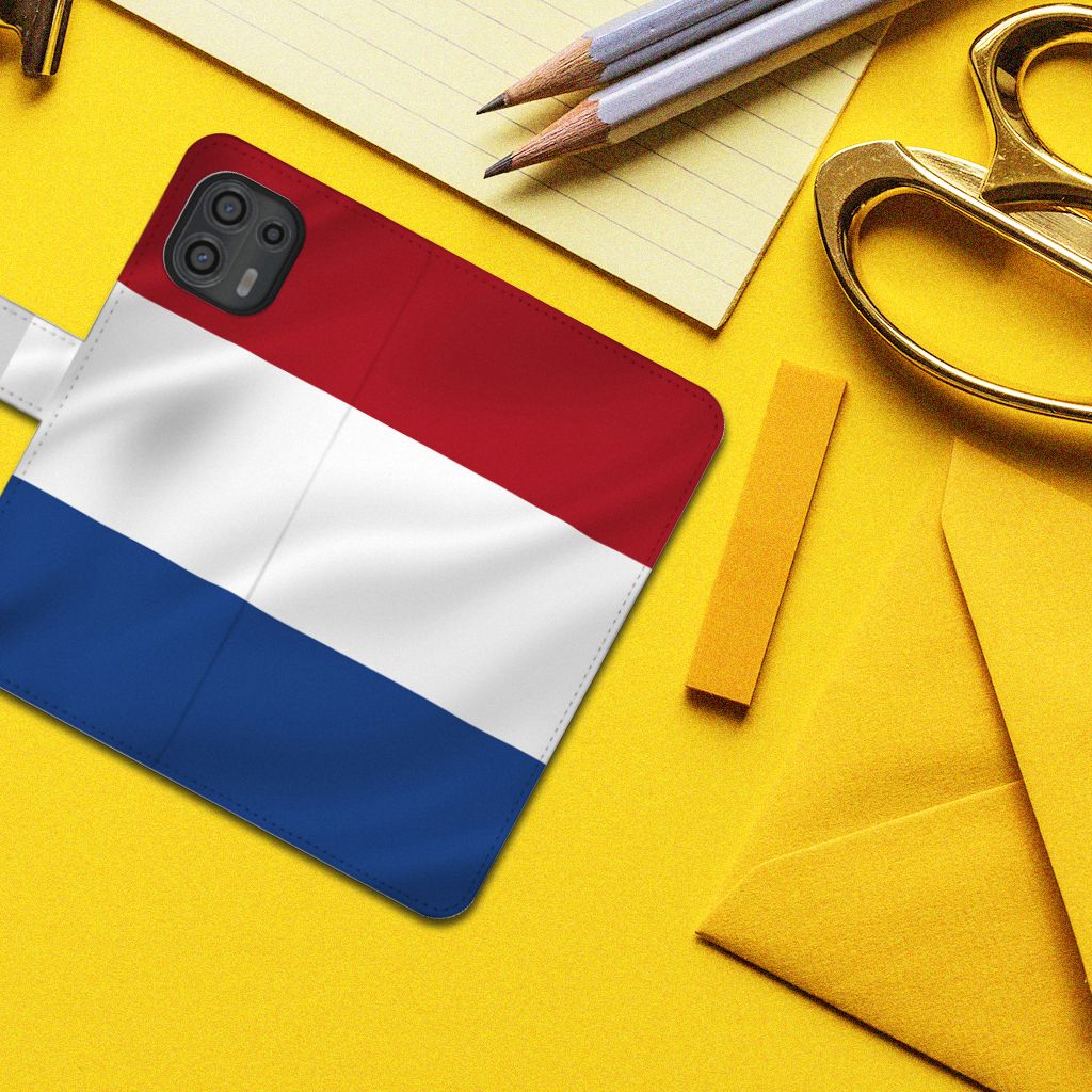 Motorola Edge 20 Lite Bookstyle Case Nederlandse Vlag op een gele achtergrond met kantoorbenodigdheden.