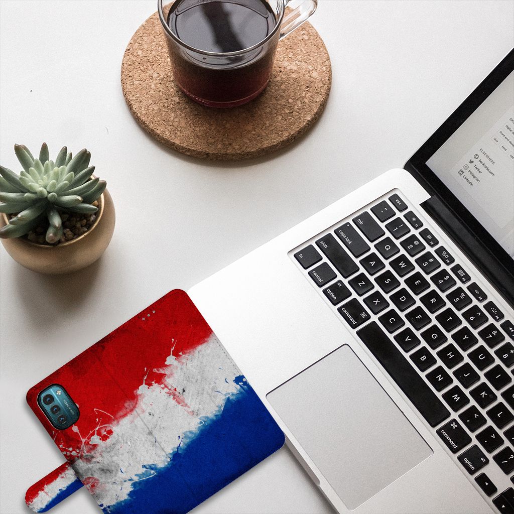 Nokia G11 | G21 Bookstyle Case Nederland met Nederlandse vlag op bureau met laptop en plant.
