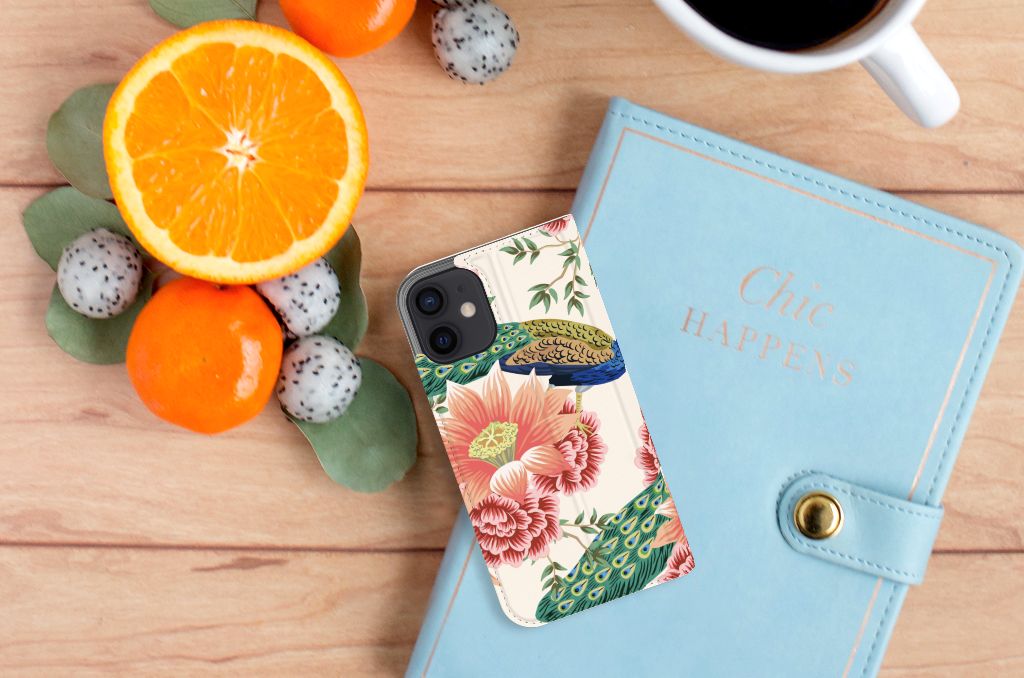 Hoesje maken voor iPhone 12 Mini Pink Peacock met bloemen en pauwen op een houten tafel met fruit en notitieboek.