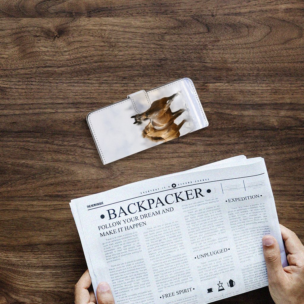 Samsung Galaxy A14 4G Telefoonhoesje met Pasjes Paarden op een houten tafel met een krant.
