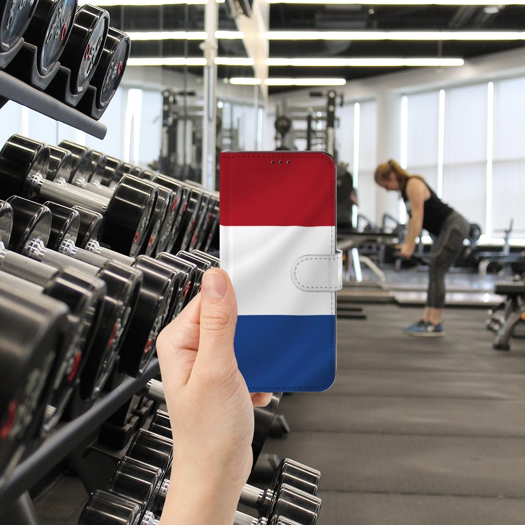 OPPO Find X5 Pro Bookstyle Case Nederlandse Vlag in gebruik bij een sportschool met halters op de achtergrond.