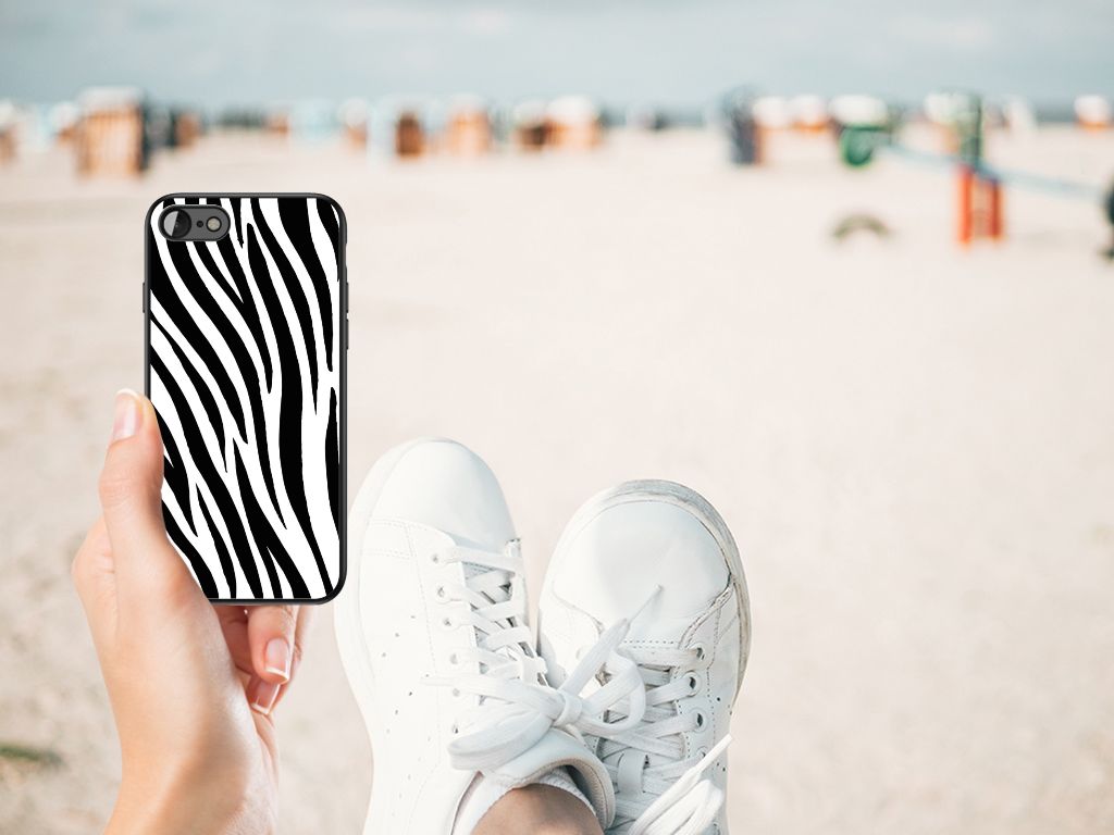iPhone SE 2022 | SE 2020 | 7/8 Dierenprint Telefoonhoesje Zebra op het strand, met witte sneakers op de voorgrond.